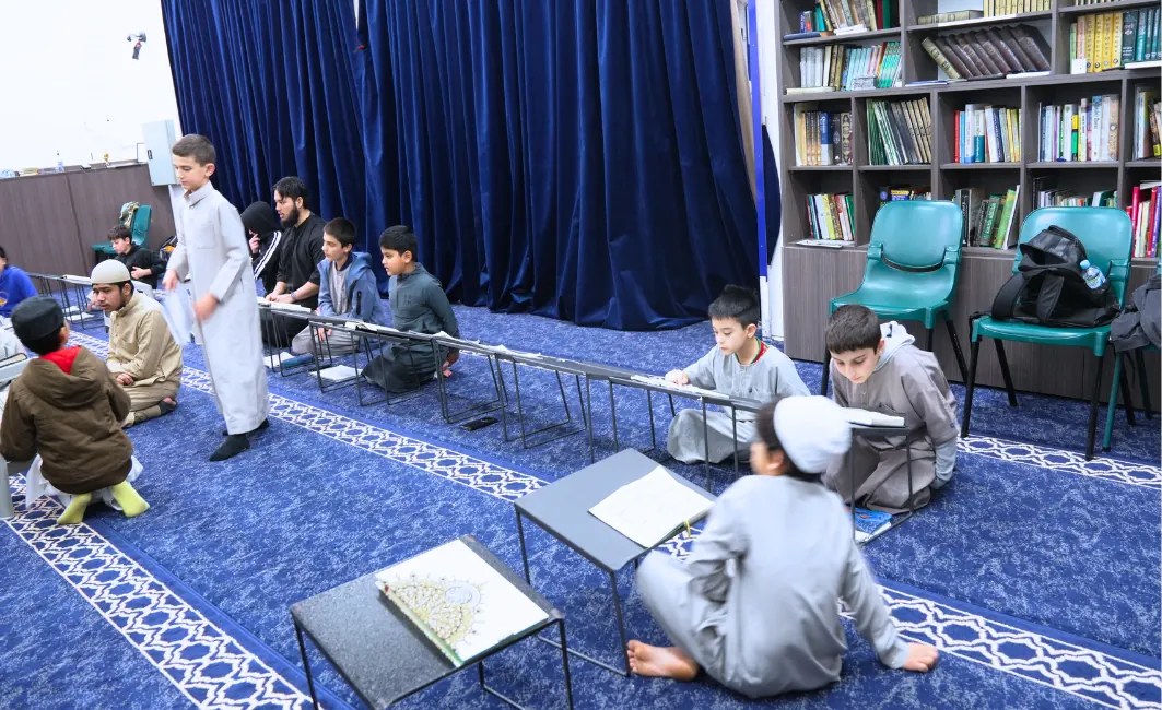 Students revising in the classroom beside the library shelves
