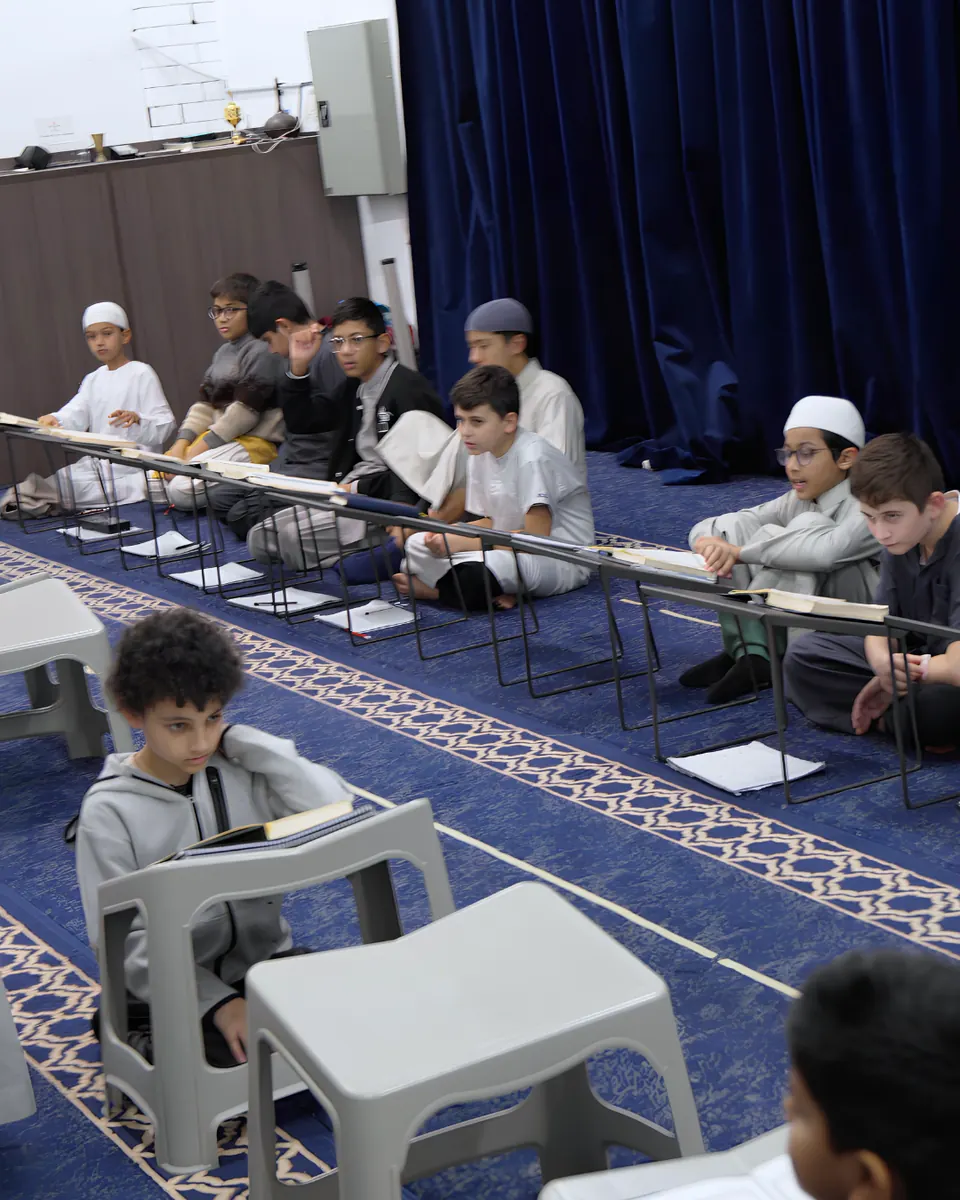 Students seated in rows revising their memorisation in the hall